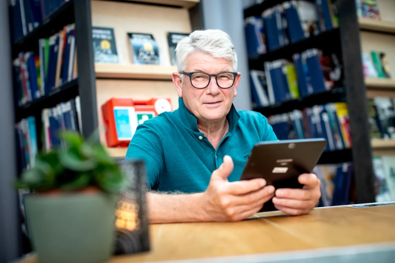 Man met ipad aan tafel 