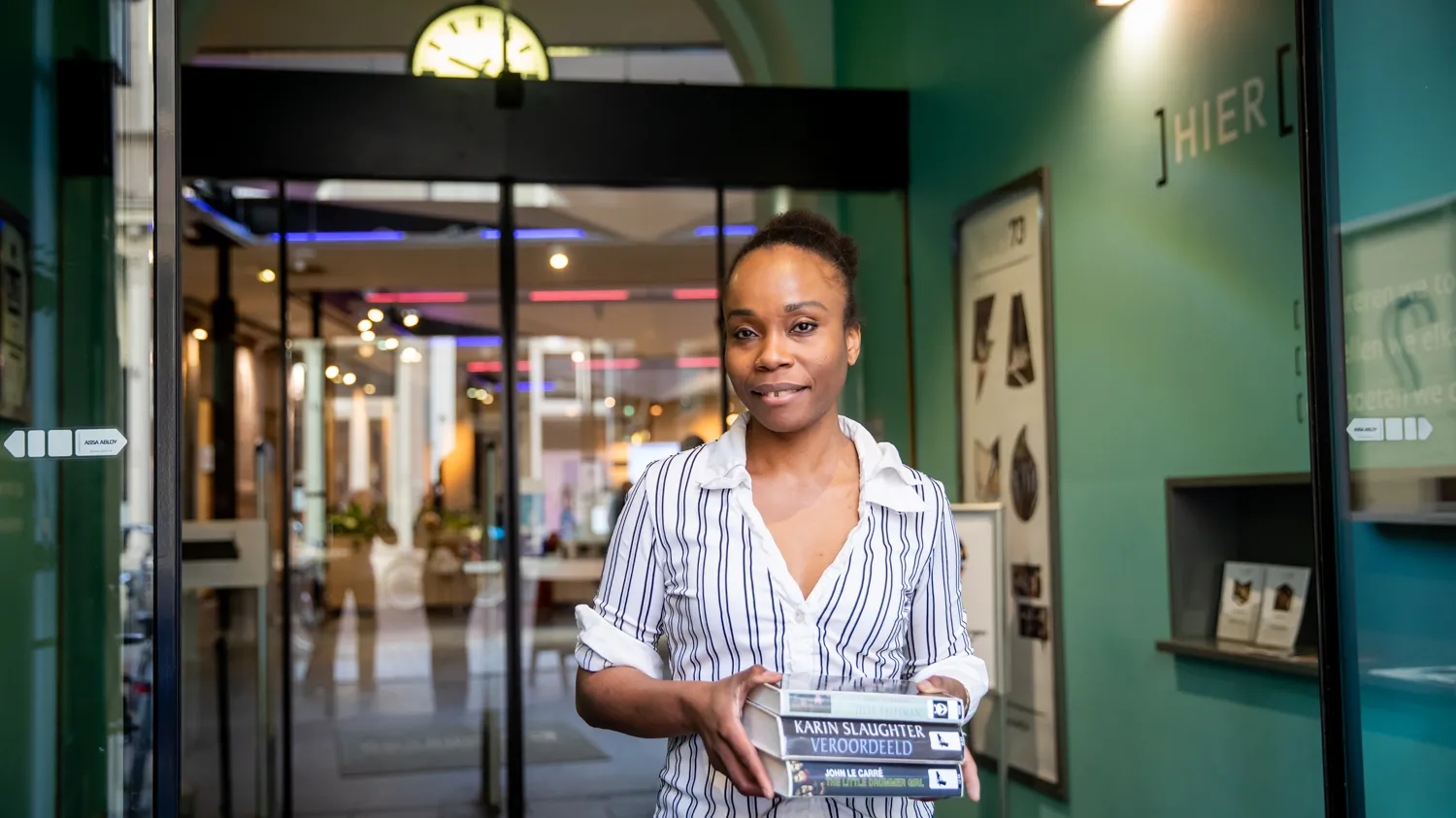 vrouw in ingang met stapel boeken