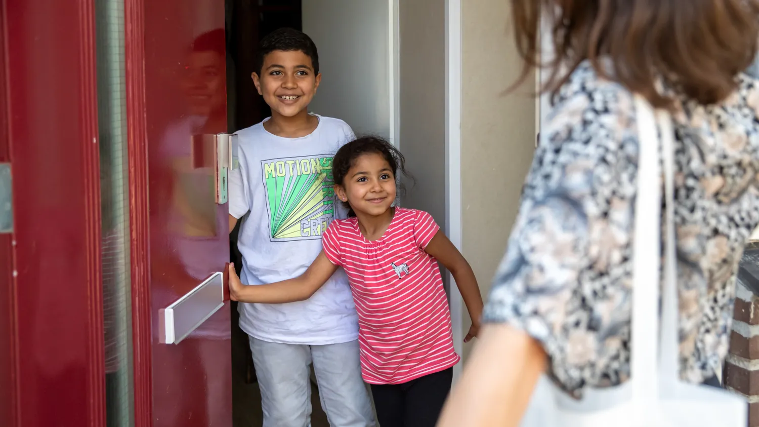 kinderen doen deur open voor vrouw