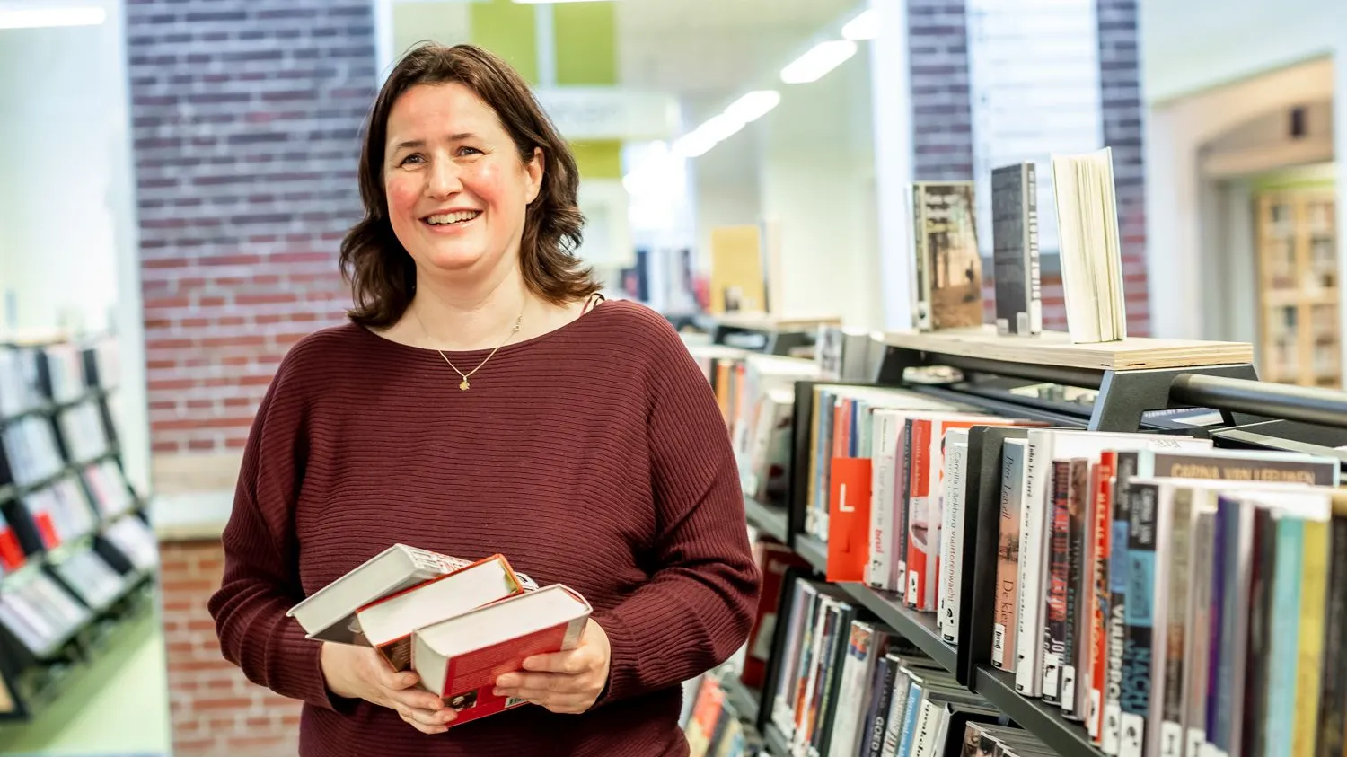 vrouw met boek voor boekenkast