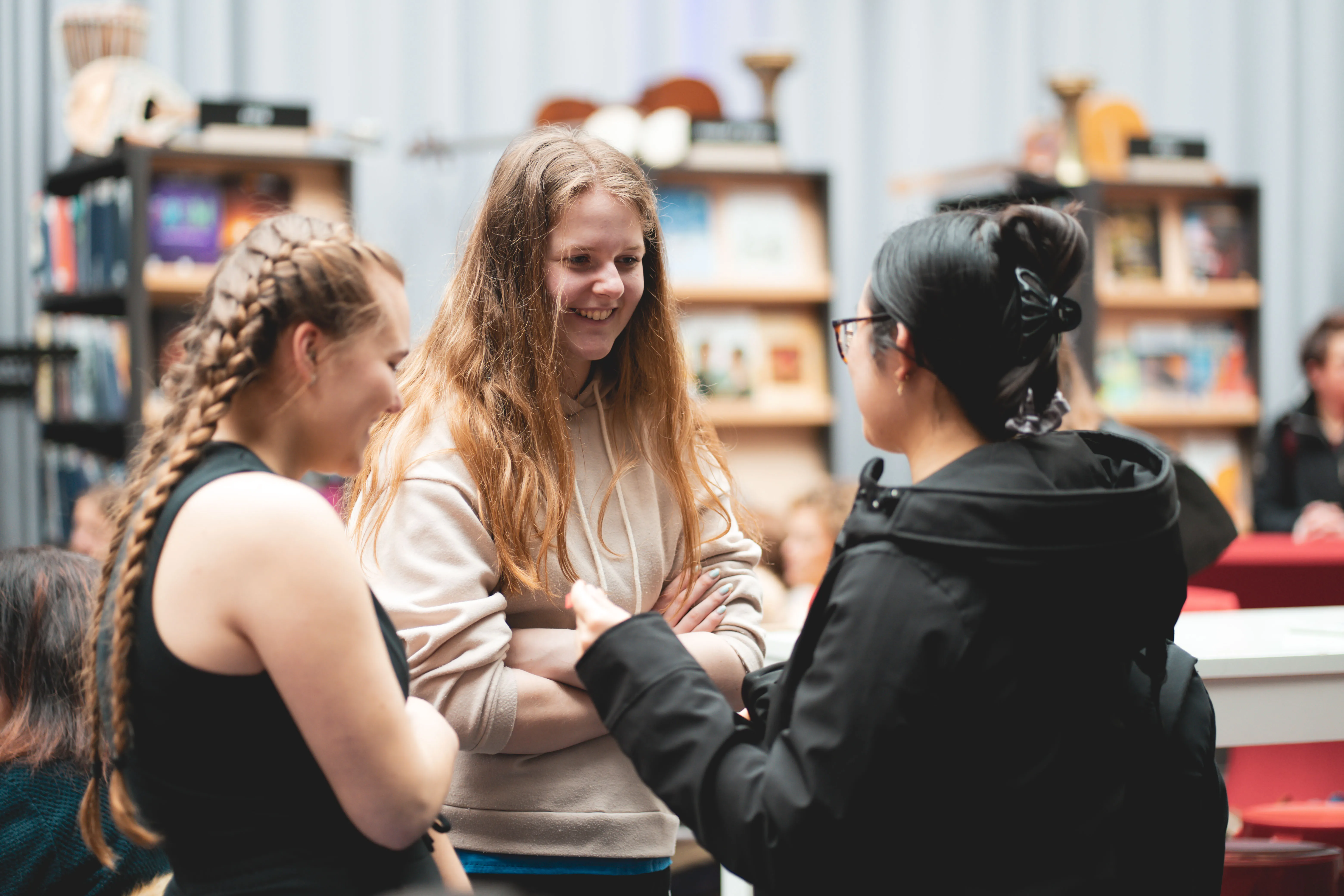 drie jonge meiden lachend met elkaar in gesprek