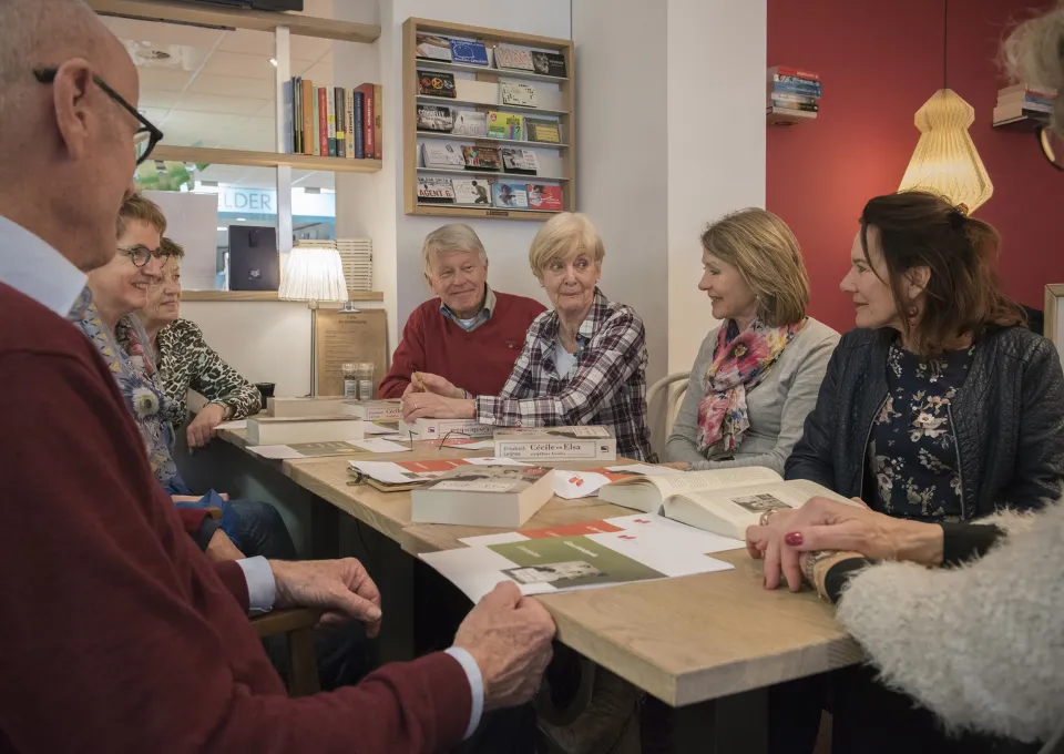 senioren rond tafel vol boeken