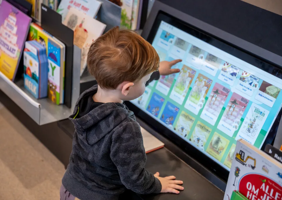 jongen voor beeldscherm met digitale prentenboeken