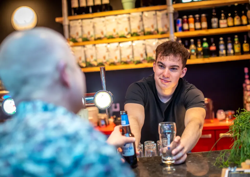 Horecamedewerker geeft drankje 