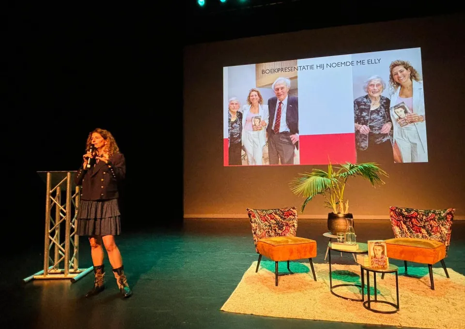 vrouw met microfoon en podium met zitje