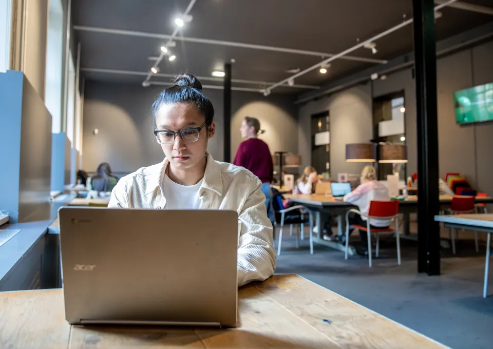 jongen achter computer in studiezaal