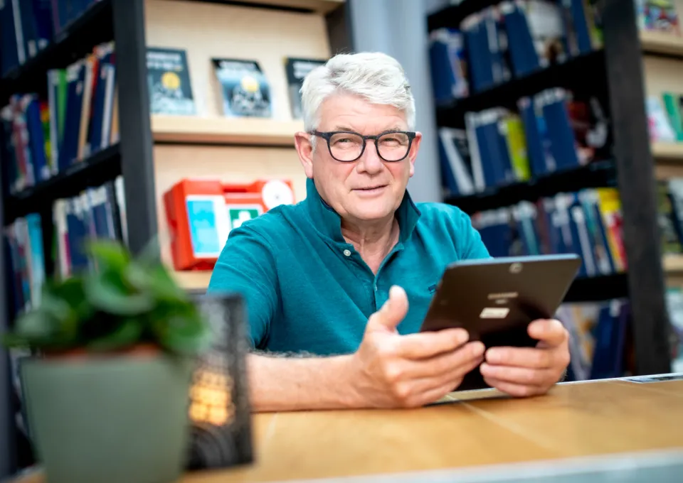 Man met ipad aan tafel 