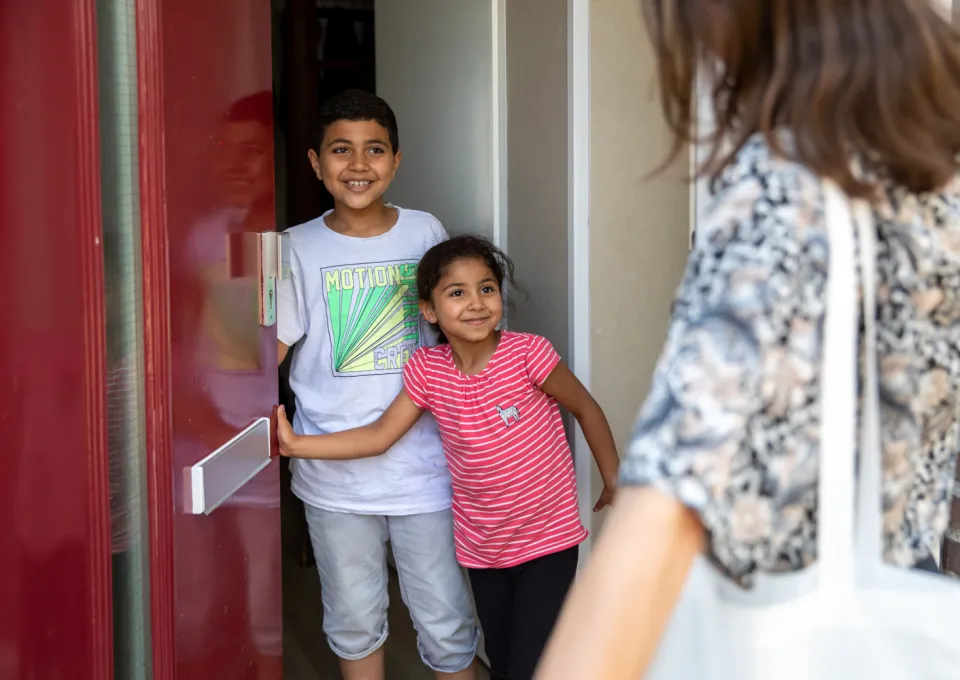 kinderen doen deur open voor vrouw