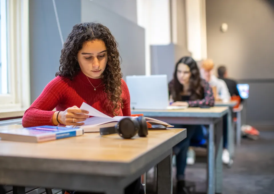 twee jonge meiden aan het studeren met boek en laptop