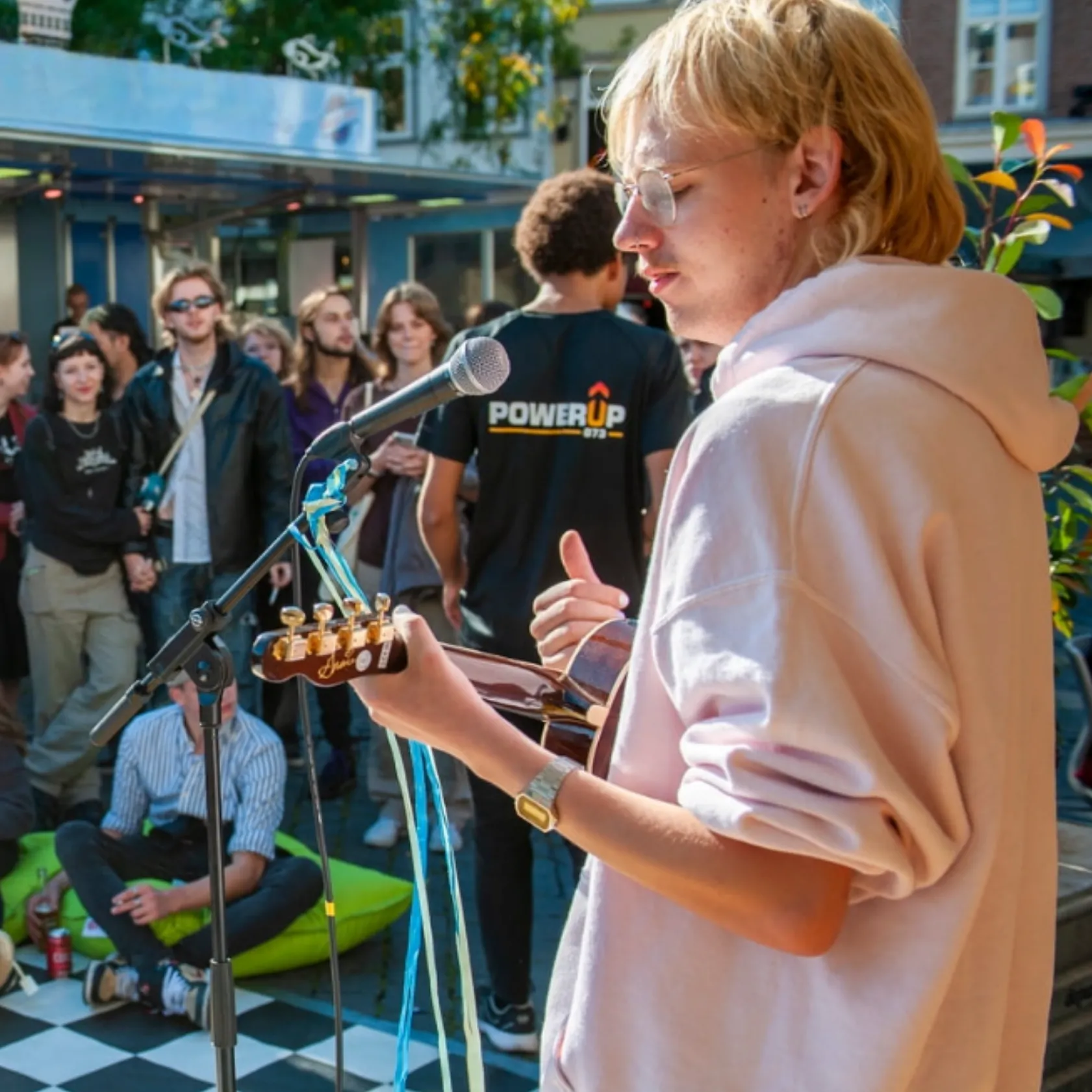 Jonge jongen treed op met gitaar voor publiek