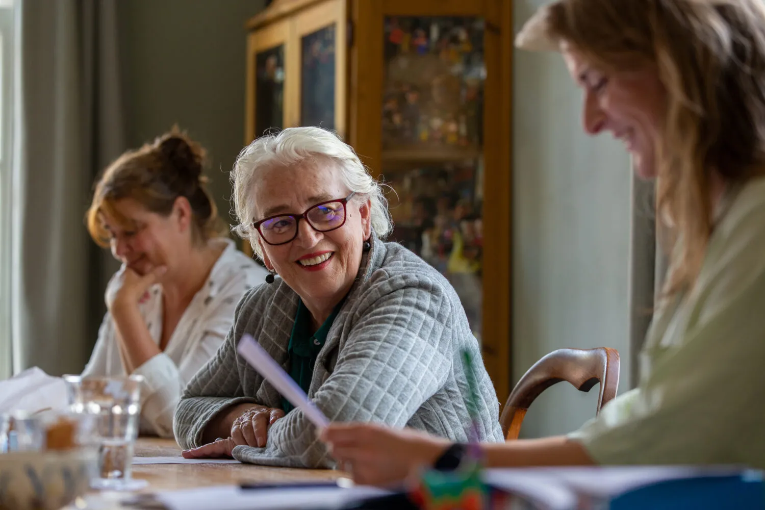 vrouwen rond tafel lezen en praten met eklaar